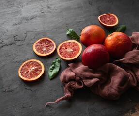Blood orange fruit with leaves on a black background with space for text. Top view