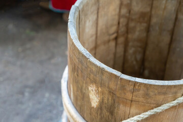 round wooden bucket dark beige closeup on a blurred background