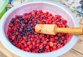 Raspberries and Blackcurrants in a bowl with a pusher
