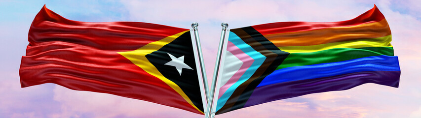 Fototapeta na wymiar Timor-Leste Flag and New LGBT Rainbow Flag waving with texture Blue sky could and sunset Double flag