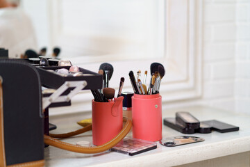 Makeup artist tools prepared for work. Set of cosmetic and airbrush over visagiste workplace background. Beauty, cosmetic and fashion. Professional makeup brushes and tools