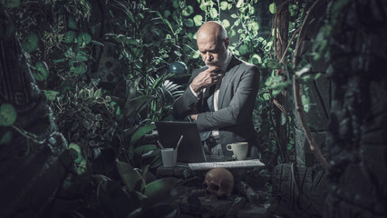 Businessman working in the jungle and thinking