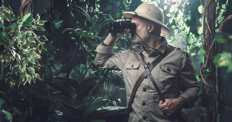 Explorer with binoculars in the jungle - obrazy, fototapety, plakaty