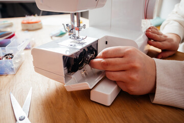 Putting the metal spool into sewing machine