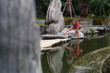 Beautiful girl in a pink t-shirt in a tropical garden