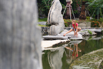 Naklejka premium Beautiful girl in a pink t-shirt in a tropical garden