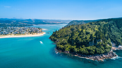 Obraz premium Boats running along a beautiful coastline. Coromandel, New Zealand.