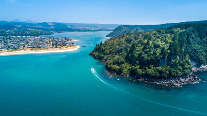 Boats running along a beautiful coastline. Coromandel, New Zealand.
