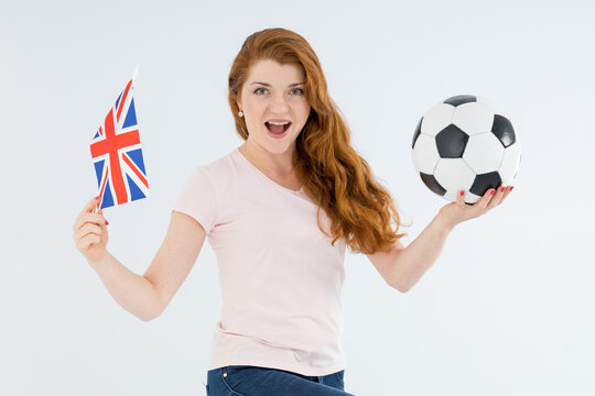 Happy red hair woman, soccer fan with ball and Great Britain flag, isolated on gray background. - Powered by Adobe