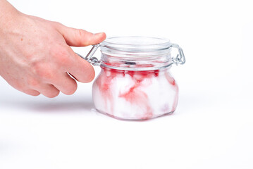 Ice cream. The man opens the ice cream. Ice cream in a glass jar with fruit. Man's hand.