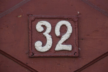 Old retro weathered cast iron plate with number 32 closeup