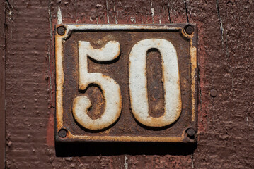 Old retro weathered cast iron plate with number 50 closeup