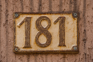 Old retro weathered cast iron plate with number 181 closeup