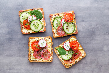Sandwiches with cream cheese, vegetables and salami.
