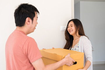 Fototapeta na wymiar Asian couple carry cardboard box to new house