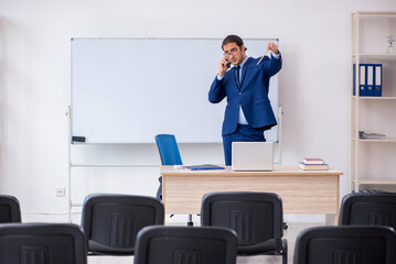Fototapeta premium Young male business trainer in the office during pandemic