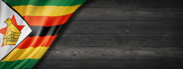Zimbabwe flag on black wood wall banner - obrazy, fototapety, plakaty