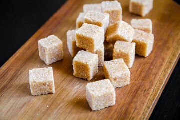 Brown cane sugar cubes on a cutting board