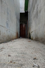 dirty road to the back door of an uninhabited house. scary old door backdrop.