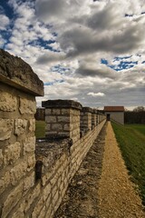 Bild von einer Steinmauer vor einem wolkigen Himmel