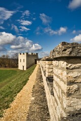 Fototapeta premium Fotografie von einer Steinmauer auf einer grünen Wiese und einem blauen Himmel im Hinterrund in Pfünz, Deutschland.