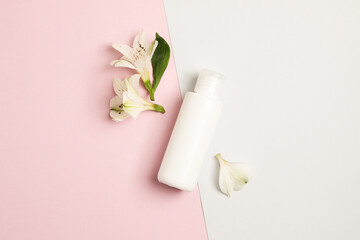 tender flatlay composition with cream flowers on pink and blue background. Concept beauty natural vitamin cosmetic product, skin care, top view