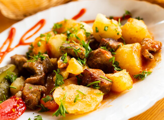 dish of baked potatoes with beef stew with herbs