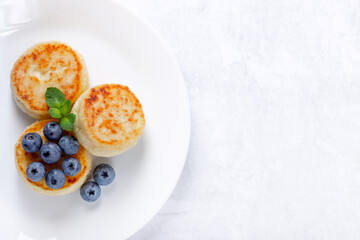 Cottage cheese pancakes with blueberry on white background, breakfast or lunch. Copy space for your text.