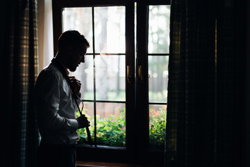 Elegant bearded groom standing by the window. Businessman in a h