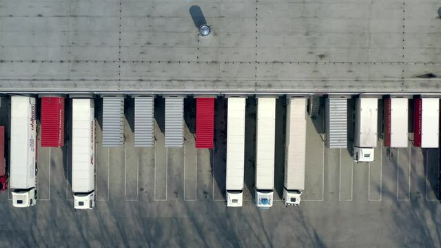 Aerial shot of truck drives up at warehouse for loading or unloading. Logistics, distribution center.
