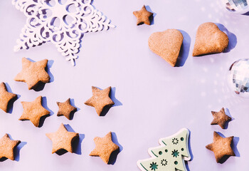 gingerbread cookies and Christmas decorations on a pink dining table. Christmas tree decorations and sweet gingerbread. sweet gingerbreads in the form of stars and hearts