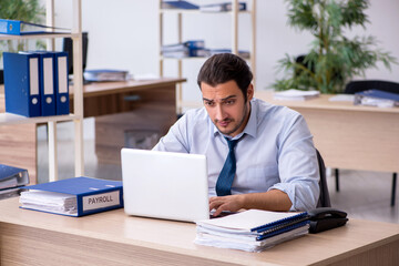 Fototapeta premium Young male bookkeeper working in the office