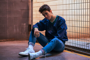 Chico guapo en fotografía urbana hípster apoyado en un verja