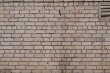 The old brick wall is white with a ventilation grate. High quality photo