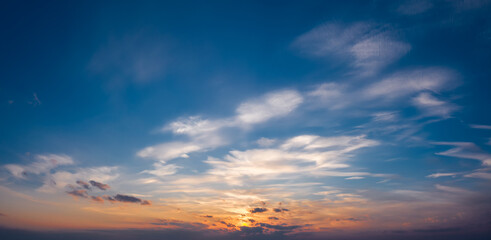 Naklejka na ściany i meble Picturesque sunset sky with clouds illuminated with dramatic sunlight.
