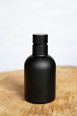 black perfume bottle packaging on white background on wooden 