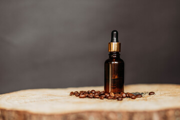 Bottle of essential oil on wooden table, on dark background with coffee beans around