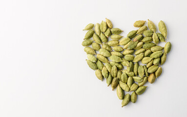 Green whole cardamom pods lay out in a heart shape isolated on a white background  with coppy space