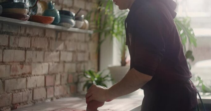 Potter kneads clay with dye in slow motion, pottery at workshop, potter prepares clay for making nerikomi style ceramics, ceramist at work, 4k 60p Prores HQ 10 bit
