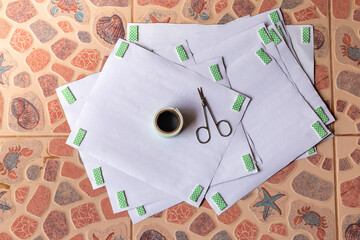Double-sided adhesive, high angle Stick behind the white paper, and small scissors on top of all the paper placed on the patterned tile floor. 