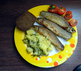 grilled river fish with bread, potatoes and tomatoes