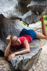 Beautiful girl in a pink t-shirt in a tropical garden