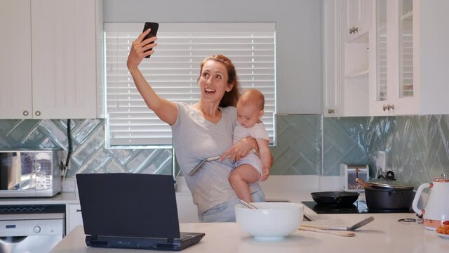 Happy mother and baby having video chat using smartphone mom holding toddler enjoying mobile technology sharing motherhood lifestyle.