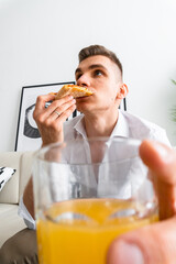 man eating pizza and drinking juice