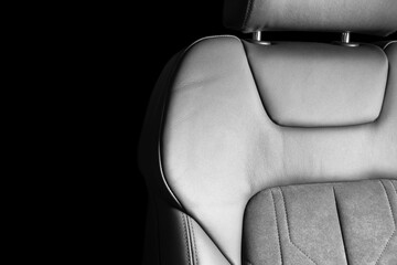 Modern luxury car black leather with alcantara interior. Part of black leather car seat details with white stitching. Interior of prestige car. Perforated leather seats isolated. Perforated leather.