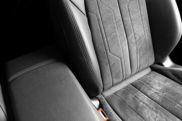 Modern luxury car black leather with alcantara interior. Part of black leather car seat details with white stitching. Interior of prestige car. Perforated leather seats isolated. Perforated leather.