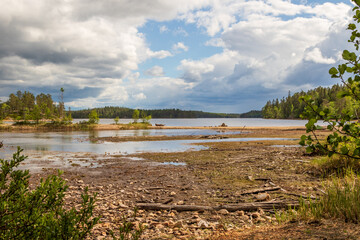 schwedische Seenlandschaft mit einsamen Strand im Vordergrund