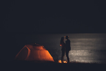 The romantic couple have rest at the night campsite near the sea
