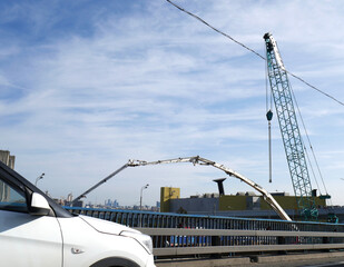 Construction work on laying a new road and pipes with a crane. Summer. Blue sky