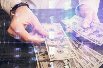 Double exposure of technology drawing hologram and us dollars bills and man hands. Data concept
